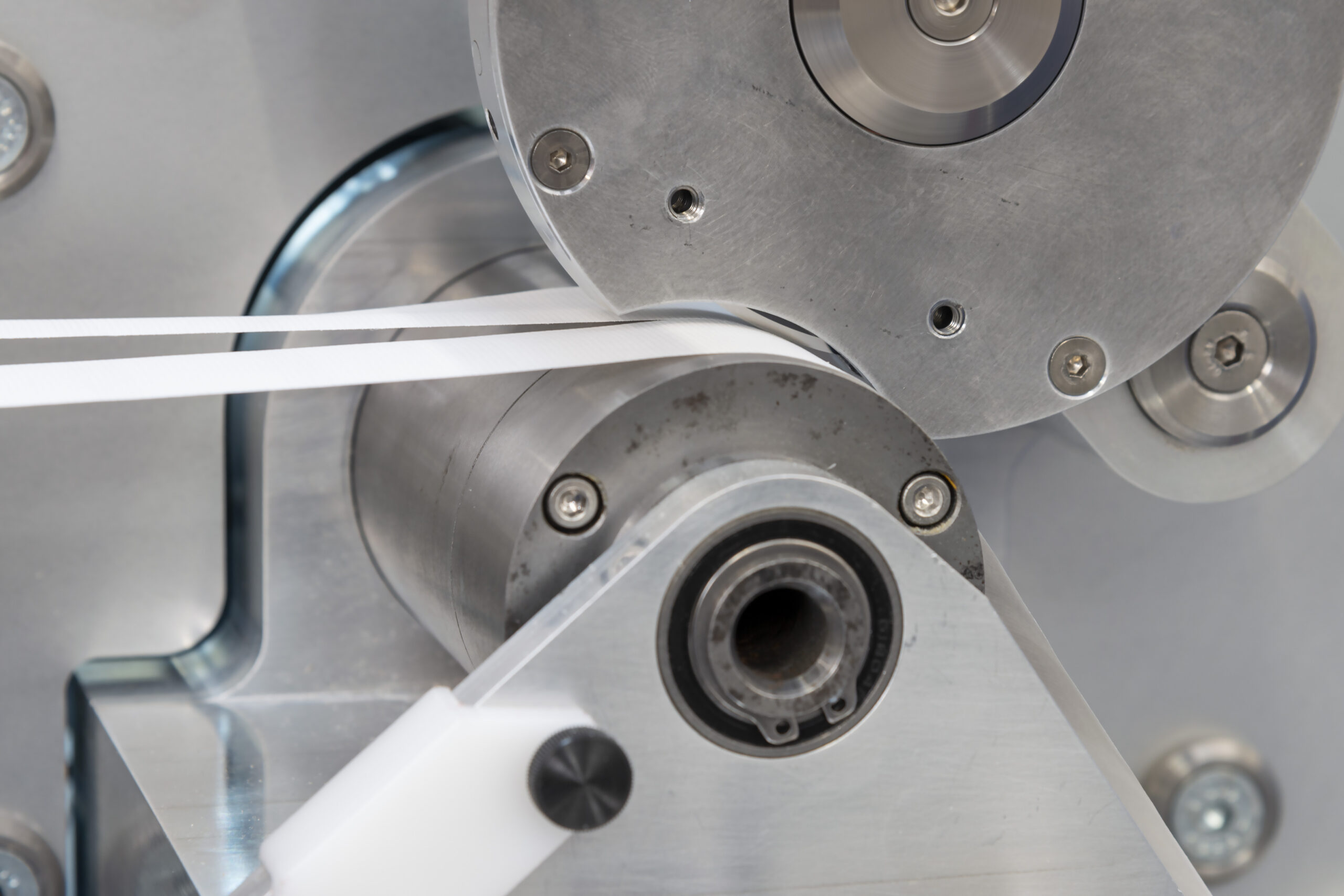 Slitting machine close up of blade showing slit paper